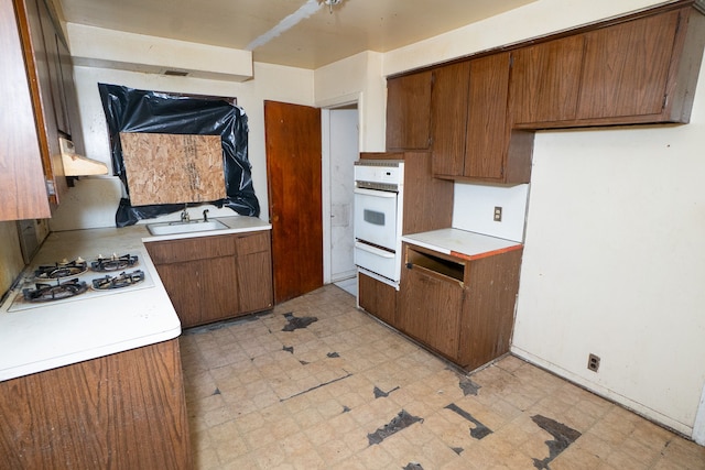 kitchen with ventilation hood, white appliances, and sink