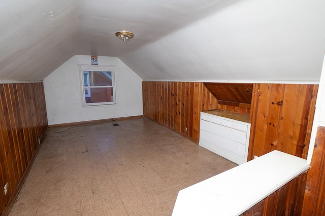 additional living space with wooden walls and lofted ceiling