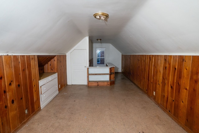 additional living space with vaulted ceiling and wooden walls