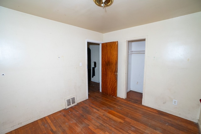 unfurnished bedroom featuring a closet and dark wood-type flooring