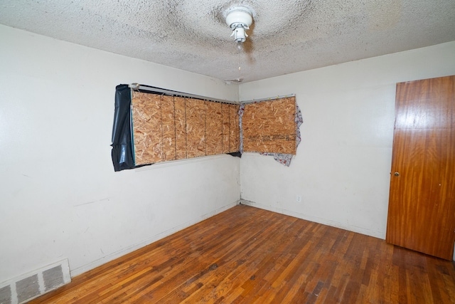 unfurnished room featuring hardwood / wood-style floors and a textured ceiling