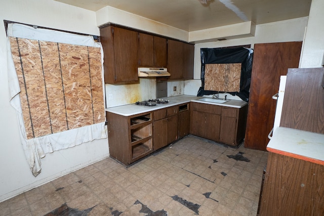 kitchen featuring dark brown cabinets, white gas stovetop, and sink