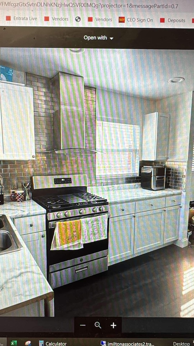 kitchen with sink, white cabinets, and gas range