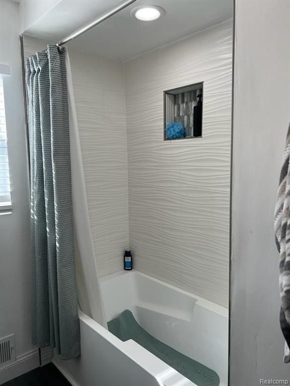 full bath featuring visible vents and shower / bath combination with curtain