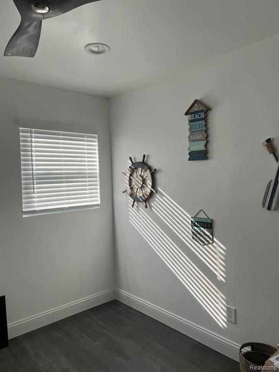 empty room featuring dark wood-type flooring and baseboards