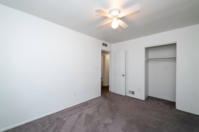 unfurnished bedroom with dark carpet, a closet, and ceiling fan