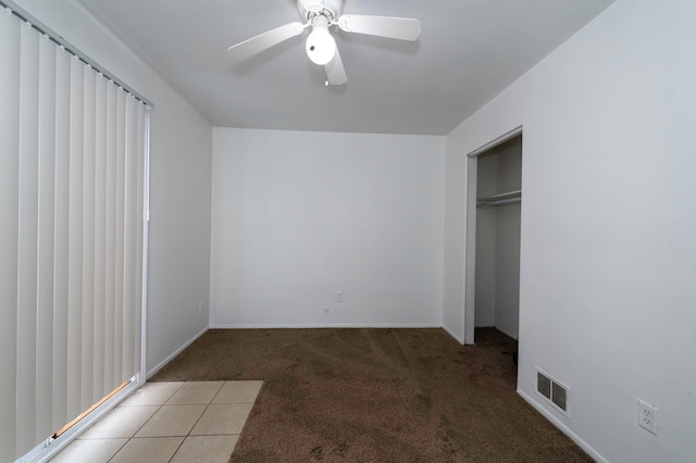 unfurnished bedroom featuring carpet floors, a closet, and ceiling fan