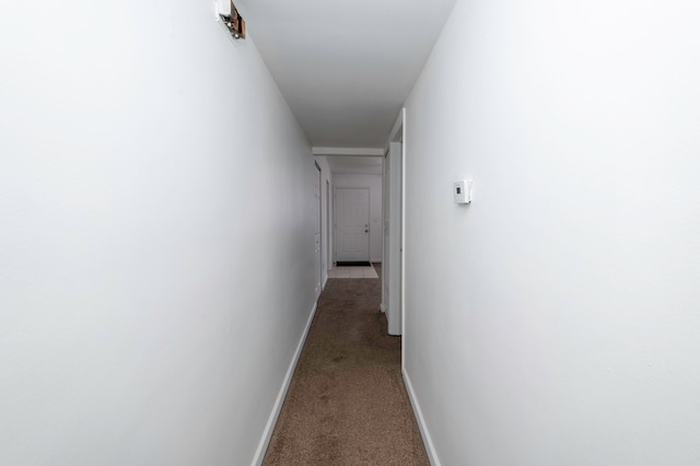 hallway featuring dark carpet