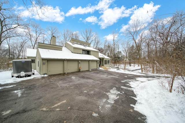 snow covered property featuring a garage