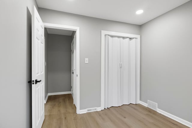 unfurnished bedroom featuring light hardwood / wood-style flooring and a closet