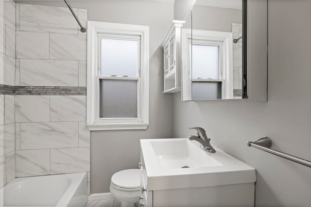 full bathroom featuring vanity, tiled shower / bath combo, and toilet