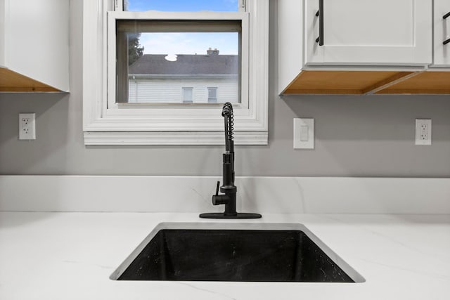 details with white cabinetry and sink