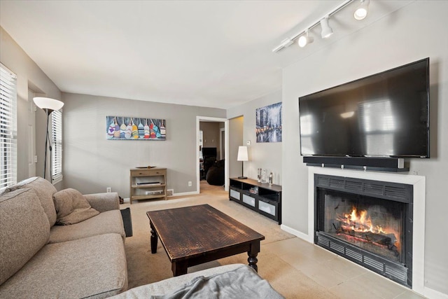 living room with a healthy amount of sunlight, rail lighting, and light colored carpet