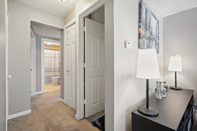 hallway featuring light colored carpet