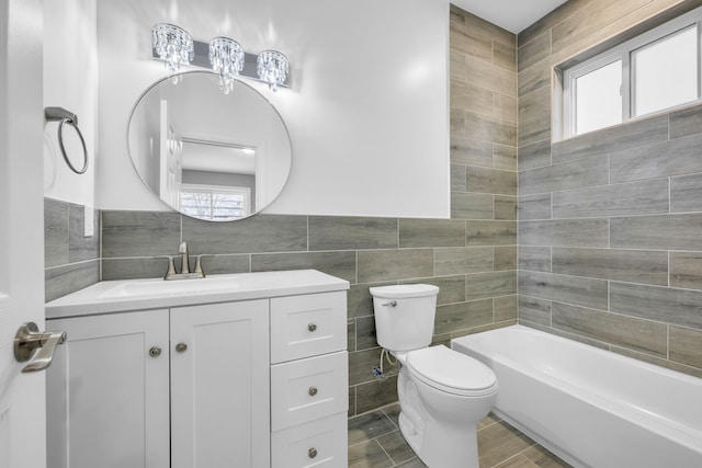 full bathroom featuring toilet, vanity, tile walls, and washtub / shower combination