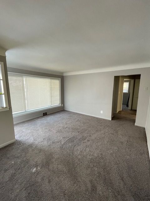 unfurnished room with dark carpet