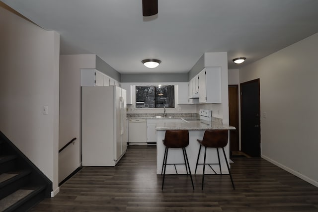 kitchen with kitchen peninsula, sink, white appliances, white cabinetry, and light stone countertops