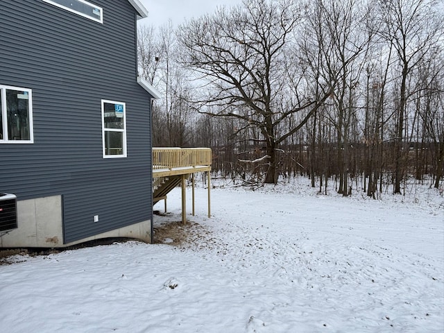 yard covered in snow with a deck