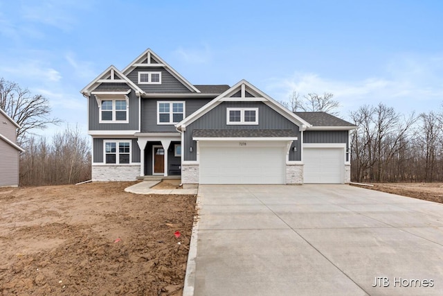 craftsman inspired home featuring a garage, concrete driveway, and a shingled roof