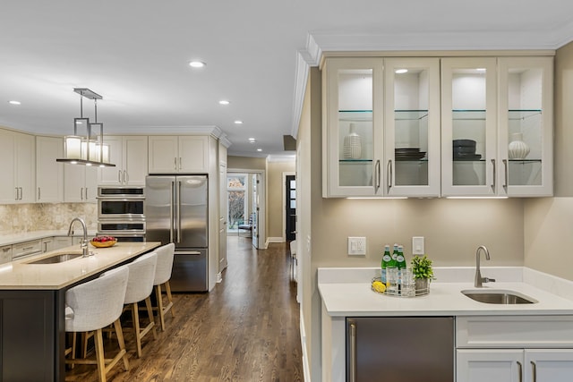 kitchen featuring crown molding, sink, decorative light fixtures, and appliances with stainless steel finishes