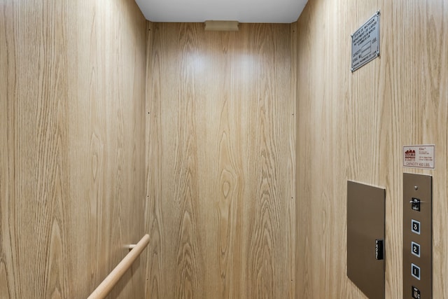 details featuring wood walls and elevator