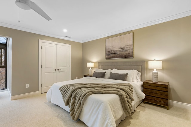 carpeted bedroom with ceiling fan, a closet, and ornamental molding