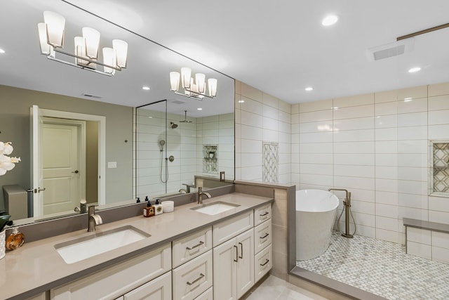 bathroom with tile patterned flooring, vanity, plus walk in shower, and a chandelier