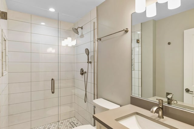 bathroom with vanity, toilet, and a shower with door