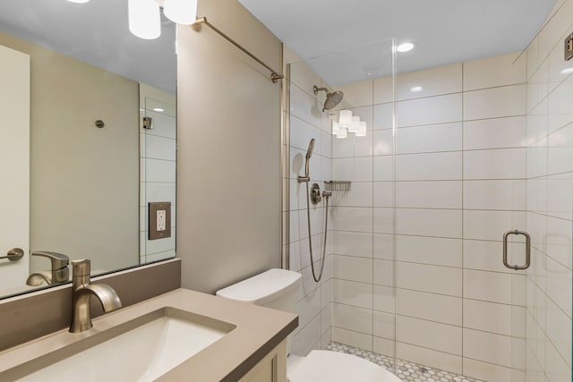 bathroom featuring vanity, a shower with shower door, and toilet