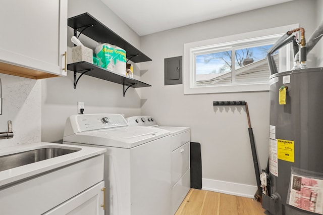 laundry room featuring cabinets, light hardwood / wood-style floors, independent washer and dryer, electric panel, and gas water heater