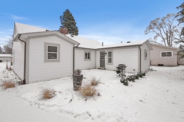 view of snow covered rear of property