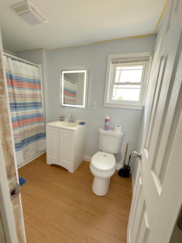 bathroom featuring curtained shower, vanity, wood-type flooring, and toilet