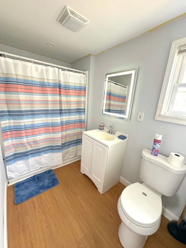 bathroom with hardwood / wood-style floors, vanity, and toilet