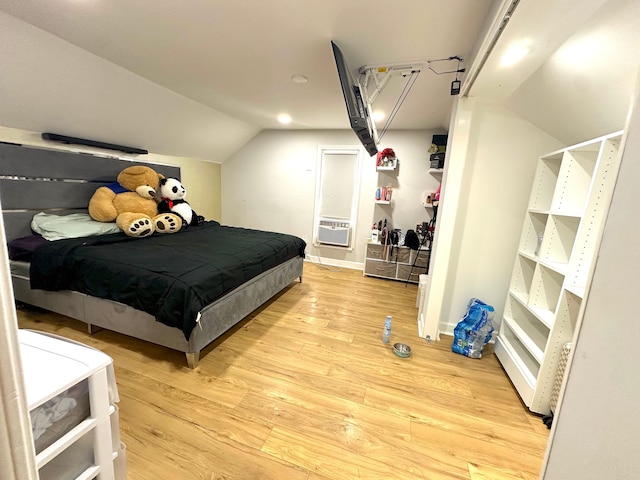 bedroom featuring lofted ceiling, cooling unit, and light wood-type flooring