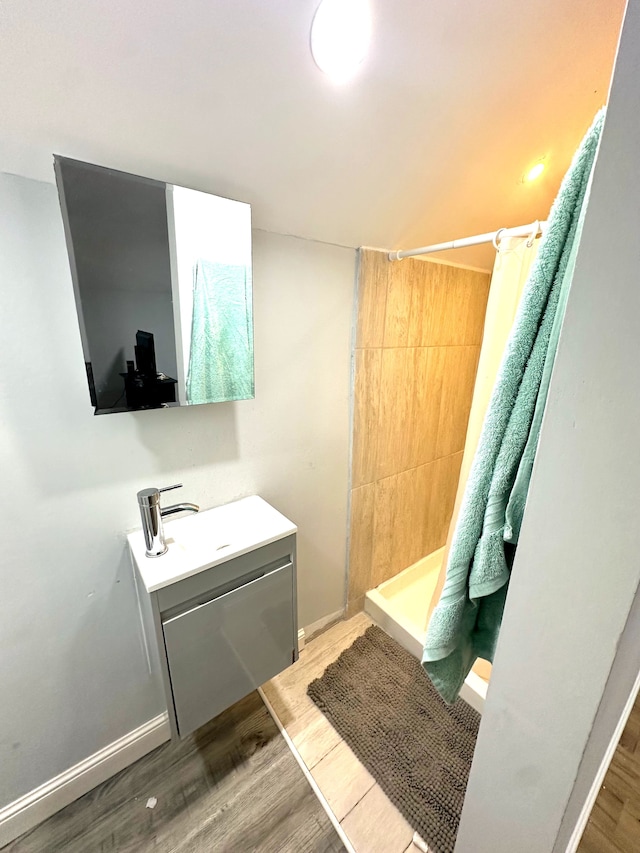 bathroom with hardwood / wood-style flooring, vanity, and walk in shower