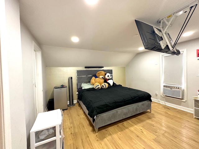 bedroom with light hardwood / wood-style floors, cooling unit, and lofted ceiling