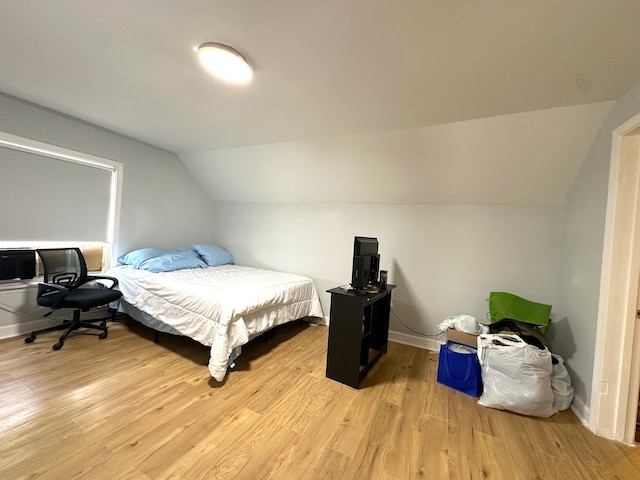 bedroom featuring light hardwood / wood-style floors and lofted ceiling