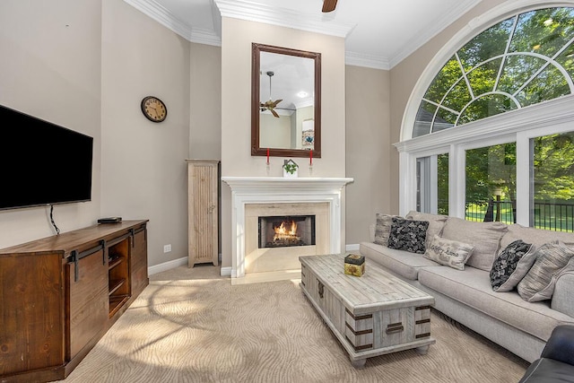 living room with ceiling fan, a premium fireplace, light carpet, and ornamental molding