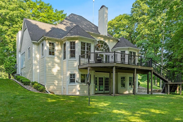 rear view of house with french doors, a lawn, and a wooden deck