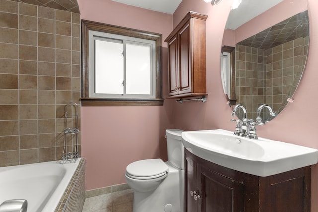 bathroom featuring toilet, tile patterned floors, tiled tub, and vanity