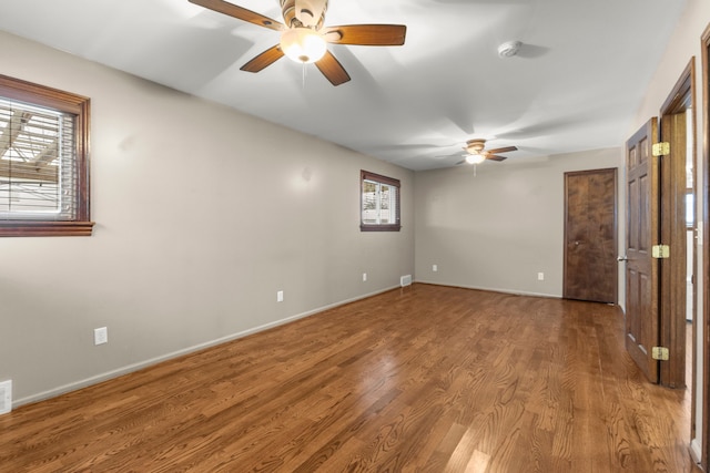 unfurnished room featuring ceiling fan, hardwood / wood-style floors, and a healthy amount of sunlight