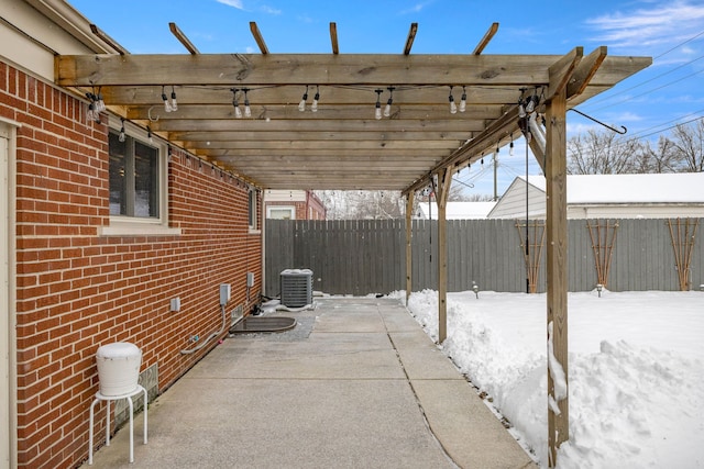 snow covered patio featuring cooling unit and a pergola