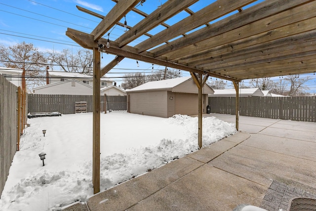 snow covered patio with a garage and an outbuilding