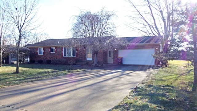 ranch-style house featuring a garage and a front lawn