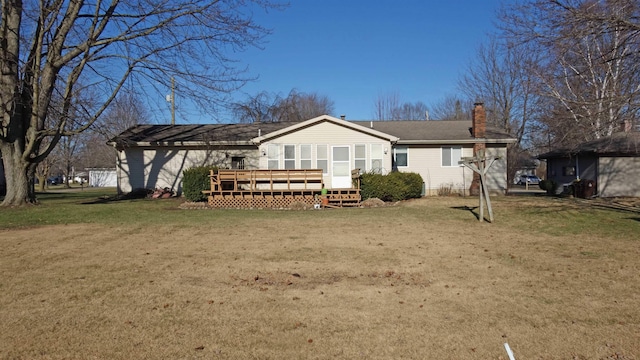 back of house featuring a lawn and a deck