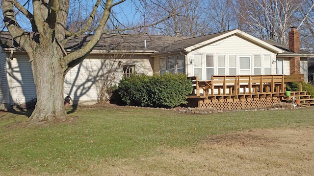 back of property with a lawn and a deck