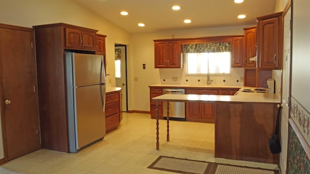 kitchen with sink, stainless steel appliances, tasteful backsplash, and vaulted ceiling