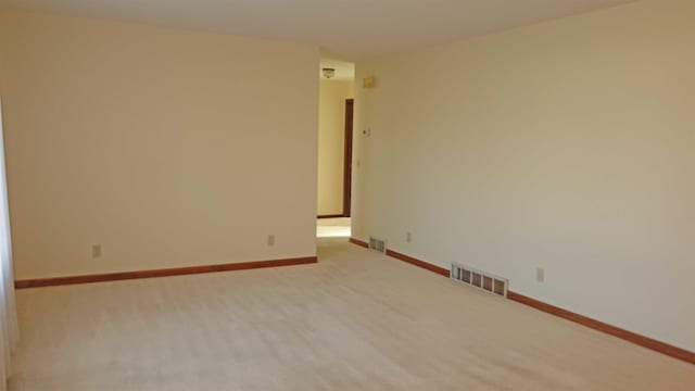 spare room featuring light colored carpet