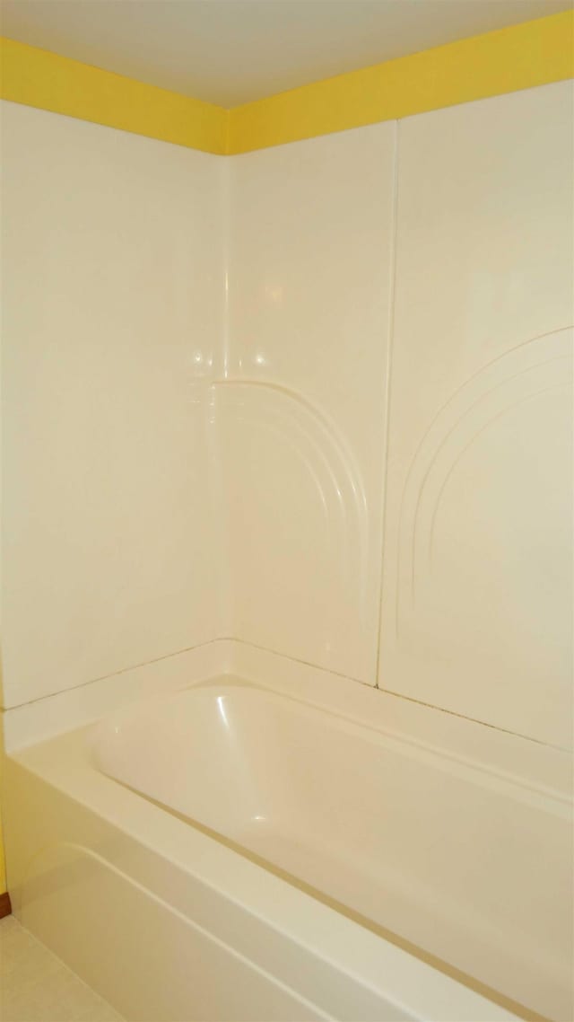 bathroom with tile patterned floors and a tub