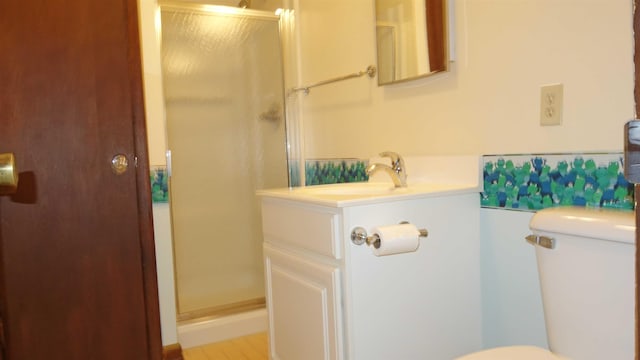 bathroom featuring vanity, toilet, and a shower with door